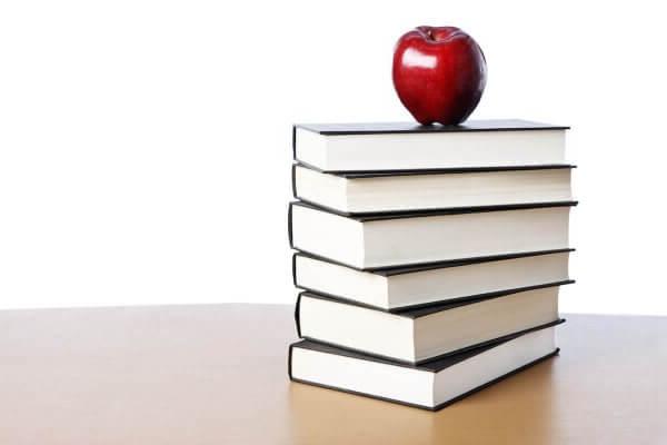 Stock photo of apple on top of books for story about Shenandoah education graduate student Sujin Chung winning VACTE scholarship.